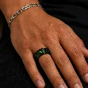 black-ceramic-ring-emerald-green-carbon-fiber-on-hand.webp